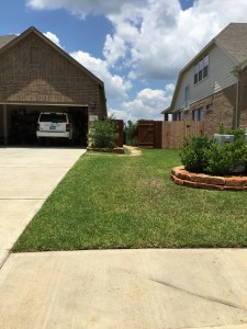 Flagstone driveway and lawn with flower bed in Katy, TX